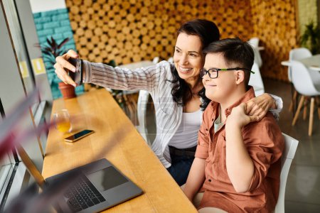 Photo for Beautiful jolly mother taking selfie with her preteen inclusive son with Down syndrome in cafe - Royalty Free Image
