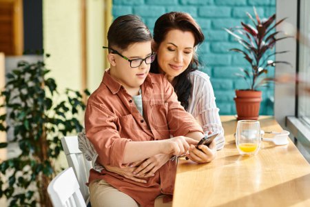 Photo for Jolly mother spending quality time with her cheerful son with Down syndrome with smartphone - Royalty Free Image
