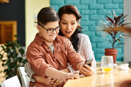 Photo for Jolly mother spending quality time with her cheerful son with Down syndrome with smartphone - Royalty Free Image