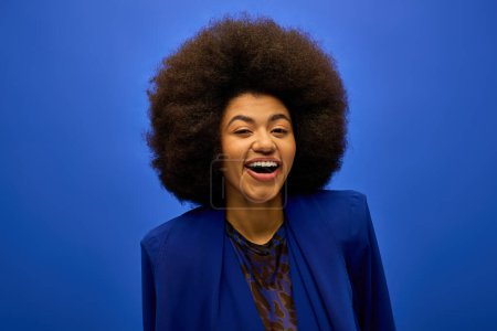 Eine stylische Afroamerikanerin lächelt selbstbewusst in die Kamera.