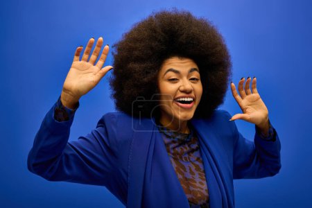 Stylish African American woman with curly hairdomaking a funny face on vibrant backdrop.