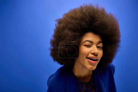 Photo for Stylish African American woman with curly hairdoin trendy attire, posing against a vibrant backdrop. - Royalty Free Image