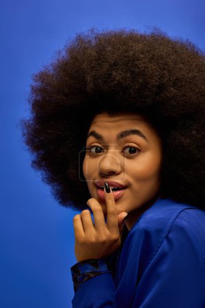 Téléchargez les photos : Fashionable African American woman with curly hairdoposes against vibrant backdrop. - en image libre de droit