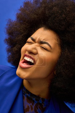 Eine Nahaufnahme einer stilvollen afroamerikanischen Person mit einer kühnen Afro-Frisur vor einem lebendigen Hintergrund.