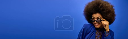 Téléchargez les photos : Homme élégant avec des cheveux bouclés capturer un moment avec caméra. - en image libre de droit