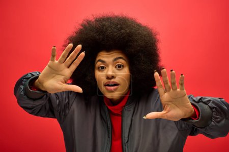 Téléchargez les photos : African american woman with curly hairdoholding his hands up in a powerful gesture. - en image libre de droit