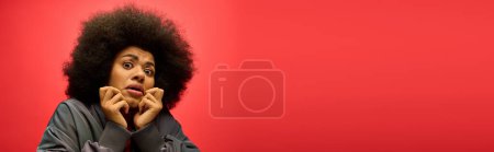 Téléchargez les photos : A woman with a voluminous afro pulls a comical facial expression. - en image libre de droit