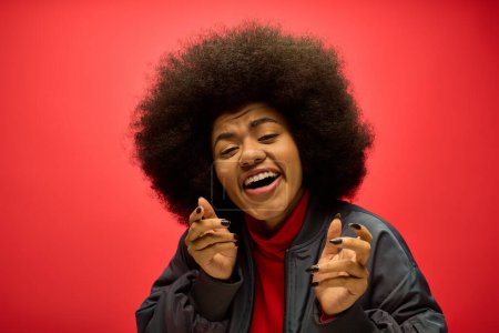 A woman with a voluminous afro hairdo is humorously contorting his face.