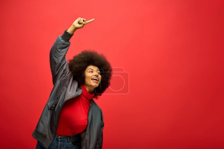 Stylish African American woman with curly hairdohair pointing confidently.