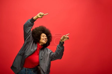 Photo for Stylish African American woman with curly hairdopointing up confidently. - Royalty Free Image