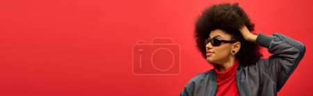 Téléchargez les photos : Stylish African American woman with curly hair and sunglasses striking a pose. - en image libre de droit