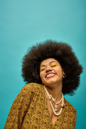 Photo for A stylish African American woman with curly hairdois smiling on a vibrant backdrop. - Royalty Free Image