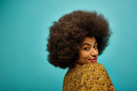 Trendy African American woman with curly hairdoposing in stylish attire against a vibrant backdrop.