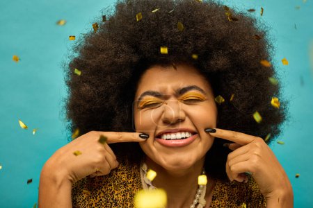Femme afro-américaine à la mode avec des cheveux bouclés sourit comme confettis tombe autour d'elle.