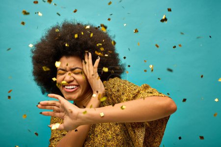 Téléchargez les photos : Femme afro-américaine élégante avec cheveux bouclés docelebrating au milieu de confettis colorés. - en image libre de droit