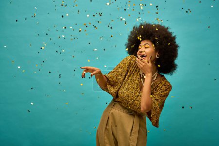 Stylish African American woman poses against blue background with confetti.