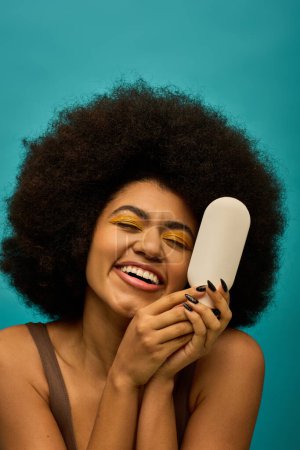 Stylish African American woman with curly hairdohair, holding a brush.