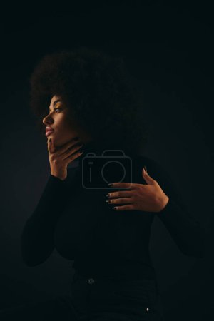 Photo for Stylish African American woman with hands on chest in trendy attire against vibrant backdrop. - Royalty Free Image