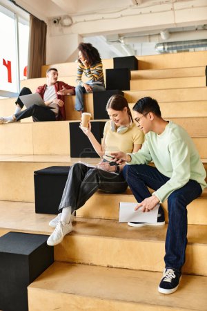 Multikulturelle Studentengruppe, die oben auf der Treppe sitzt, in Konversation und Kontemplation vertieft