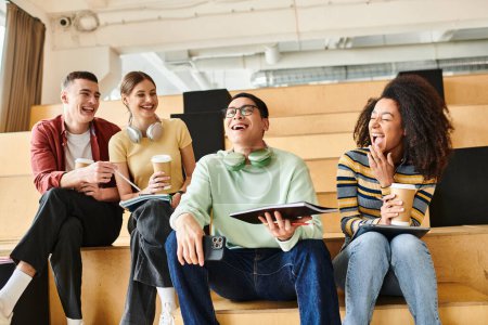 Multicultural students casually sit on a wooden bench indoors, enjoying each others company
