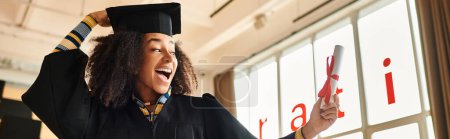 Afroamerikanische Studentin trägt stolz Abschlussmütze und -kleid und feiert ihre akademischen Leistungen, Banner
