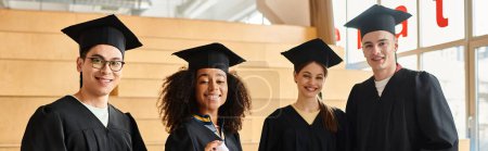 Grupo multicultural de estudiantes con gorras y batas de graduación celebrando el éxito académico en interiores.