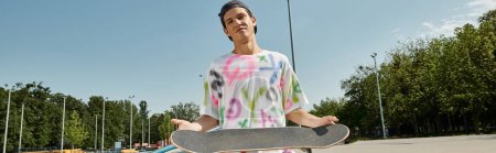 Ein stylischer junger Mann hält sein Skateboard auf einem Parkplatz bereit, um mit seinem nächsten Trick auf die Straße zu gehen.