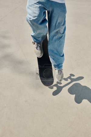 A young skater boy gracefully rides a skateboard on a smooth cement surface in a vibrant skate park on a sunny summer day.
