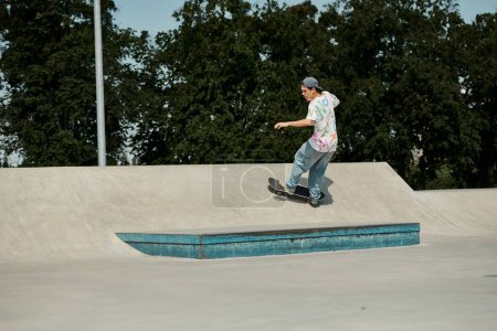 Téléchargez les photos : Un jeune patineur monte en toute confiance sa planche à roulettes sur le côté escarpé d'une rampe dans un skate park extérieur ensoleillé. - en image libre de droit