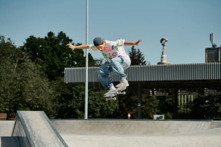 A young skater boy exhilaratingly skateboards through the air in a summer day at an outdoor skate park.