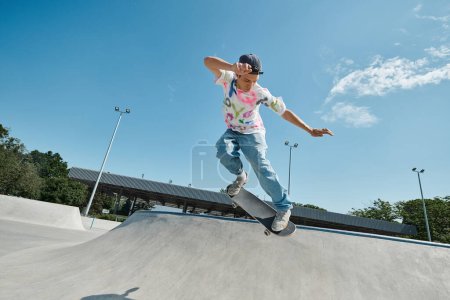 Téléchargez les photos : Un jeune homme skateboard en toute confiance sur le côté d'une rampe dans un skate park extérieur ensoleillé, montrant ses compétences et sa passion pour le sport. - en image libre de droit