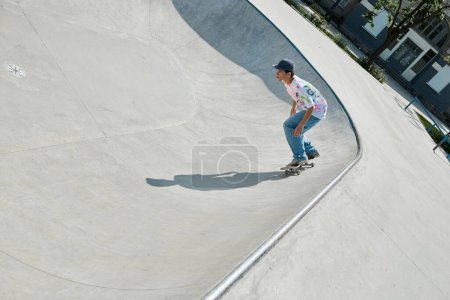A young skater boy rides a skateboard up a ramp in a sunny outdoor skate park on a summer day.