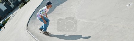 A young skater boy fearlessly accelerates down the ramp at a skate park on a sunny summer day.