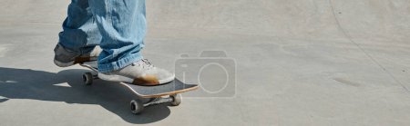 Photo for A young skater boy showcases his skills as he rides a skateboard on a cement surface in a vibrant urban skate park on a sunny day. - Royalty Free Image