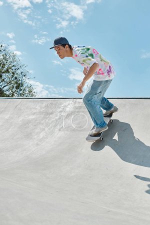 Foto de Un joven y atrevido skater monta su monopatín al lado de una rampa en un soleado parque de skate al aire libre en un día de verano. - Imagen libre de derechos