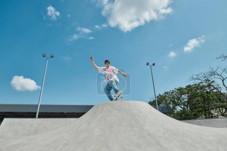 Foto de Un niño patinador está montando su monopatín sin miedo por el lado de una rampa vertical en un parque de skate en un día soleado de verano.. - Imagen libre de derechos