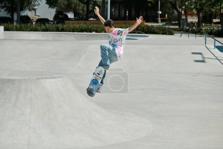 Téléchargez les photos : Un jeune homme défie la gravité alors qu'il monte habilement sa planche à roulettes sur la rampe dans un parc de skate extérieur dynamique un jour d'été. - en image libre de droit