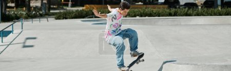 Foto de Un joven hábilmente monta su monopatín al lado de una rampa en un parque de skate en un día soleado de verano.. - Imagen libre de derechos