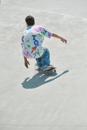 A young skater boy confidently rides a skateboard down a cement ramp in a vibrant outdoor skate park on a sunny summer day.