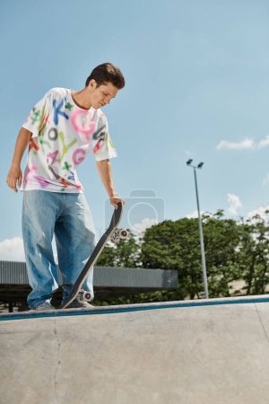 Foto de Un niño patinador sin miedo monta su monopatín al lado de una rampa en un parque de skate en un día soleado de verano.. - Imagen libre de derechos
