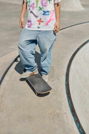 Photo for A young skater boy defies gravity as he rides his skateboard up the side of a ramp at a skate park on a sunny summer day. - Royalty Free Image