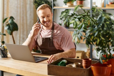 Un hombre, dueño de una tienda de plantas, realiza negocios en un teléfono celular en su escritorio con determinación.