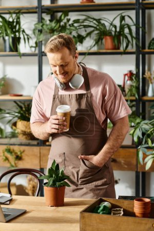 A handsome man in an apron enjoying a cup of coffee in his plant shop, embodying the idea of owning a small business.