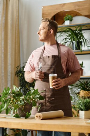 Un hombre en un delantal disfruta de un momento de relajación, sosteniendo una taza de café en una tienda de plantas.