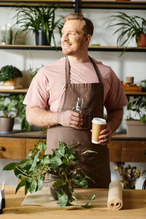 A man in an apron holding a cup of coffee in a plant shop.