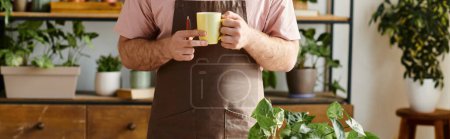 Téléchargez les photos : Homme cultivé tenant paisiblement une tasse dans ses mains tout en s'occupant de plantes dans son petit magasin de plantes. - en image libre de droit