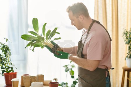 Foto de Un hombre guapo delicadamente sostiene una planta próspera en sus manos en su propia tienda de plantas, encarnando la esencia del espíritu empresarial y el cuidado. - Imagen libre de derechos