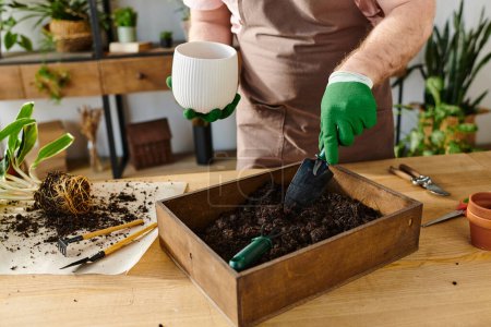 A man in an apron and gloves is digging dirt into a box in a plant shop, focusing on his own business.