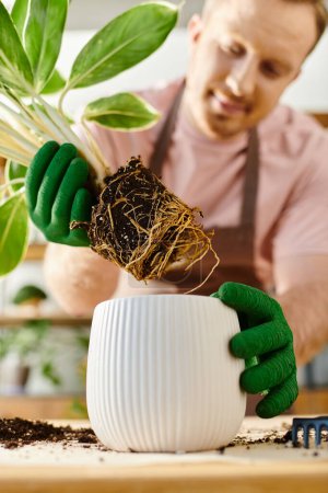 Foto de Un hombre delicadamente sostiene una planta en maceta, mostrando sus raíces con cuidado en una pequeña tienda de plantas, encarnando una verdadera conexión con la naturaleza. - Imagen libre de derechos