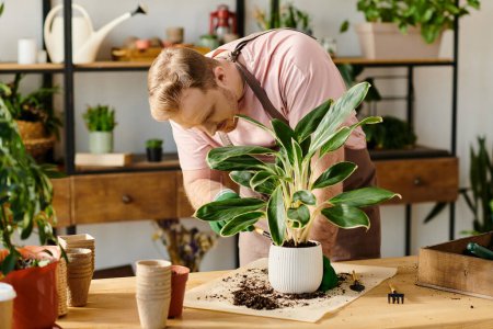 A man gracefully bends over a potted plant on a table, caring for its growth in a small business setting.